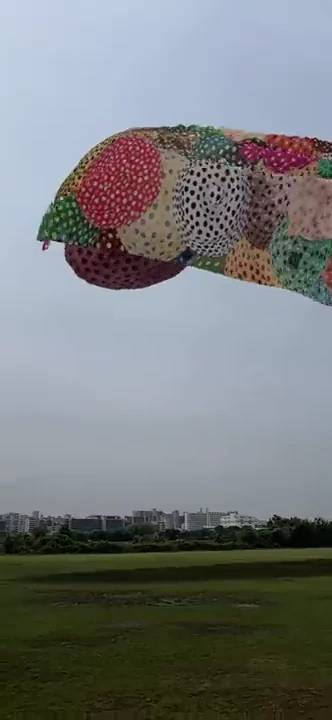 荒川河川敷の街並みより大きく見える点描作品のAR画面